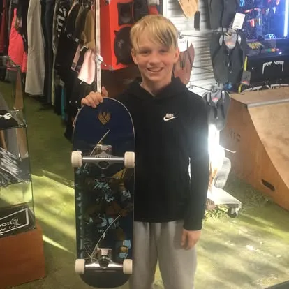 Happy customer with custom-built skateboard at Boardgarden Napa